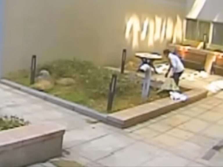 Blurred, low-resolution CCTV still of staff placing a large sack onto a handcart at the Anyang Officetel.