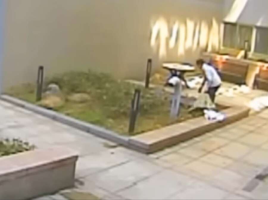 Blurred, low-resolution CCTV still of staff placing a large sack onto a handcart at the Anyang Officetel.